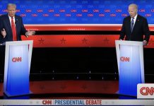 U.S. President Biden and Trump debate issues like immigration, border security and more from behind podiums on a stage.
