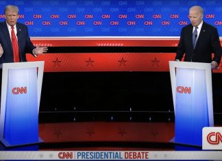 U.S. President Biden and Trump debate issues like immigration, border security and more from behind podiums on a stage.