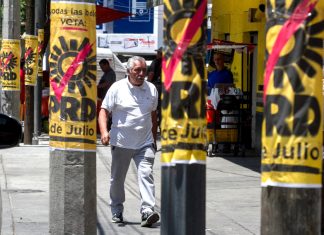 A man walks by PRD campaign posters on posts in Mexico City