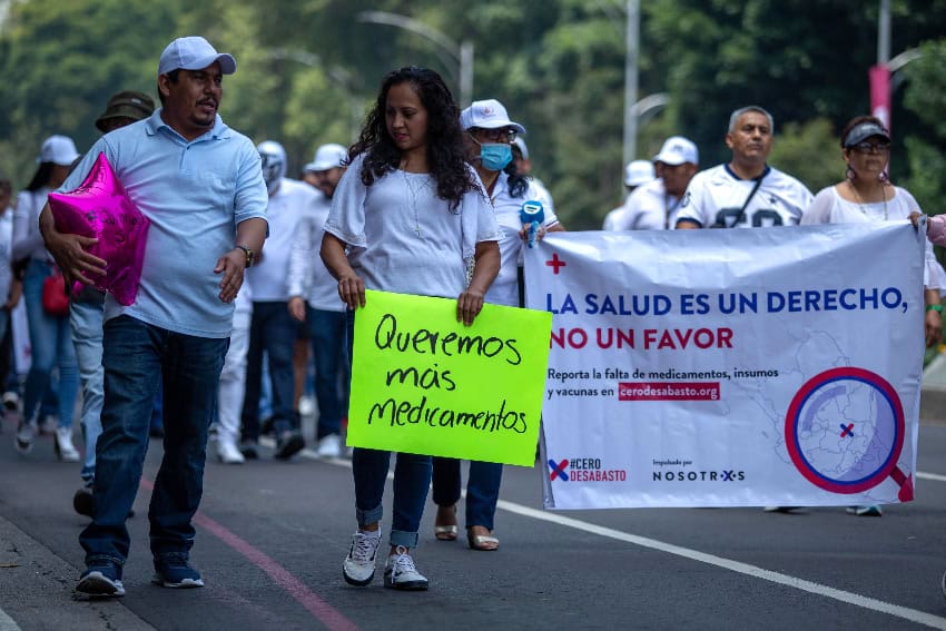 Protesters hold signs demanding medicines
