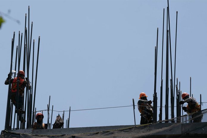 979421_Calor Trabajadores de la Construcción-1_web Moises Pablo Nava Cuartoscuro Construction workers setting up the metal support rods to a building, an image to illustrate foreign investment in Mexico