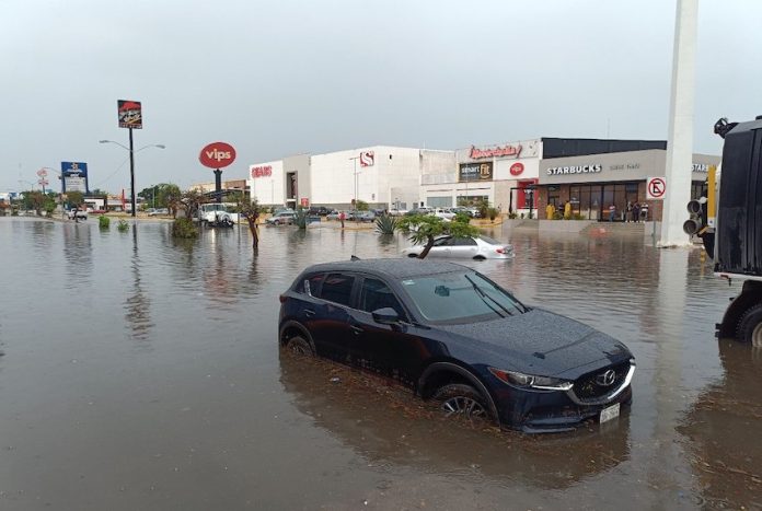 GQ4xdJUaQAAk9oh Car with water nearly up to its wheel well in severe flooding on a street in Merida, Yucatan