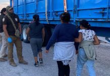 Two women and a child walk toward INM agents in Mexico