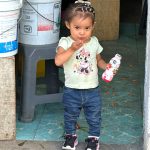 Little girl standing in a doorway blowing a kiss
