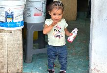 Little girl standing in a doorway blowing a kiss