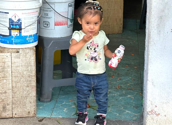 Little girl standing in a doorway blowing a kiss